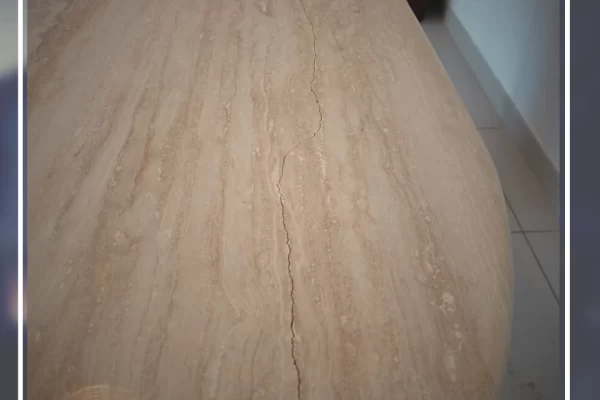 Travertine tabletop before restoration – visible holes, cracks, and dull finish.